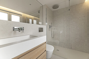 Bathroom corner with floating white oak wood furniture with marble structure on the sink, mirror integrated into the wall,