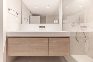 Frontal image of a bathroom with floating white oak wood furniture with marble structure on the sink