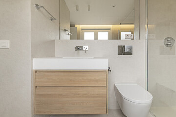 Fototapeta na wymiar Bathroom front with modern design floating furniture made of white oak wood, mirror integrated into the wall