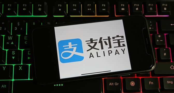 Viersen, Germany - January 9. 2024: Closeup of smartphone on pc keyboard with logo lettering of chinese Alipay