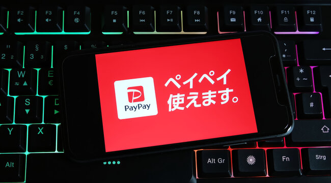 Viersen, Germany - January 9. 2024: Closeup of smartphone on pc keyboard with logo lettering of japanese PayPay