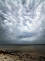 Vertical format of mammatus clouds from an approaching storm on a bay.