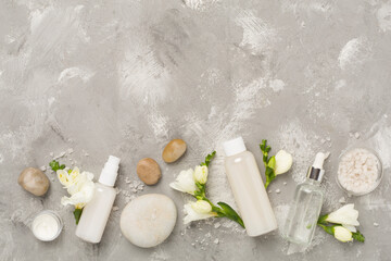 Flat lay with spa products and flowers on concrete background