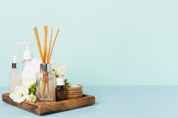 Spa composition with freesia flower and aroma diffuser on wooden table - obrazy, fototapety, plakaty