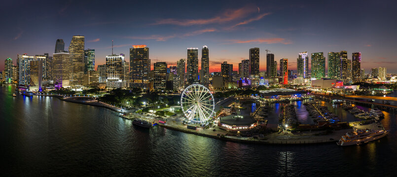 American urban landscape at night. Miami marina and Skyviews Observation Wheel at Bayside Marketplace with reflections in Biscayne Bay water and skyscrapers of Brickell, city's financial center