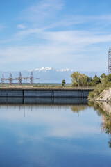 The Tagus river, surrounded by an electric dam, shows cables, mountains, water, vegetation, nature and transmits tranquility.