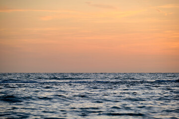 Fototapeta na wymiar Dramatic red ocean waves at sunset with soft evening sea dark water