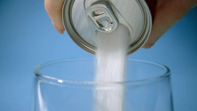 Pouring lots of sugar from soda can in glass in metaphor of sugar content of refresh drink