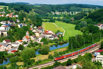 Altmühltal, village of Solnhofen, red train, green meadows, landscape, river Altmühl and rock...