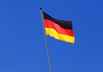 german national flag on a pole, blue sky as background, Germany