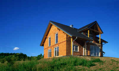 rough construction of a german single-family house, picture is from 2003, with blue sky in a warm sunlight, near Munich, Bavaria, Germany