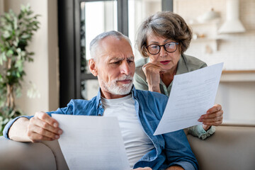 Senior old elderly spouses grandparents reading documents, having issue problem debt with money loss, doing paperwork together at home. Mortgage, loan and commerce procedures - obrazy, fototapety, plakaty