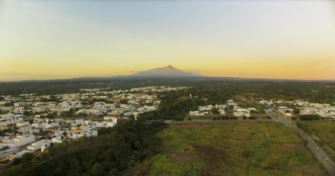 View of the Colima volcano area and northern part of the city at sunset. Landscape seen from a drone.