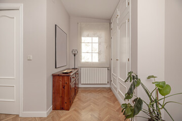 Fototapeta na wymiar Distributor of a home with built-in white wooden wardrobes