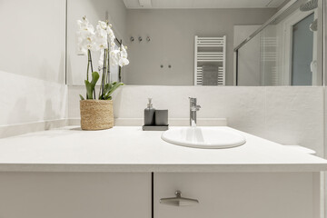 a modern design bathroom with mirrors integrated into the wall and beige stone countertop on wooden...
