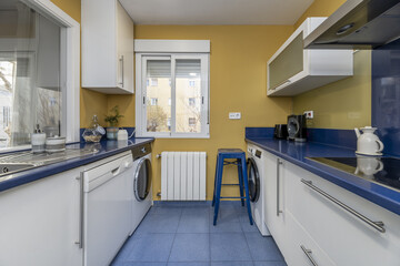 Kitchen furnished in maritime style colors with navy blue countertop