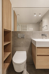Toilet of a small bathroom with oak furniture