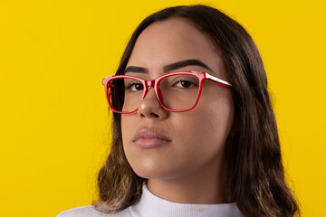 young woman wearing a white blouse and glasses on yellow background