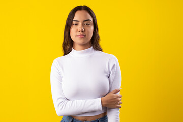 Young, happy woman wearing a white blouse, happy on yellow background