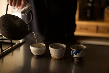 鉄瓶で沸かしたお湯を湯呑みに淹れているところ