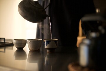 鉄瓶で沸かしたお湯を湯呑みに淹れているところ