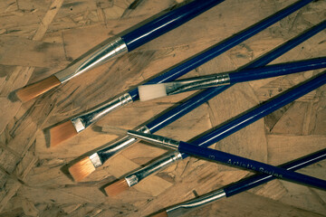 Paint brushes on wooden background 