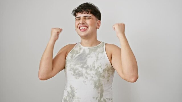 Yes! young man in sleeveless t-shirt, joyfully celebrating win with arms raised. victorious expression, standing isolated on white background.