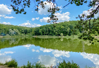 Fototapeta na wymiar A lake surrounded by trees and blue sky