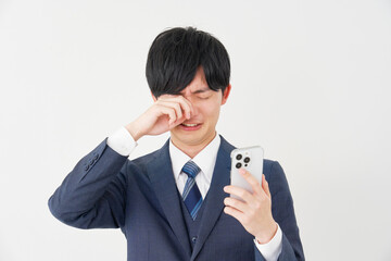 スマートフォンを持って泣くビジネスマン　白背景