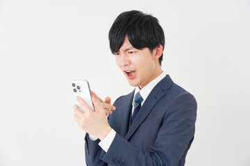スマートフォンを見て怒るビジネスマン　白背景