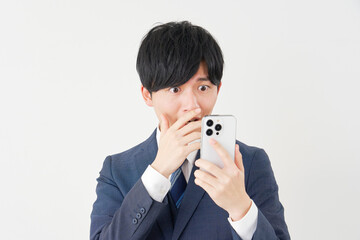 スマートフォンを見て驚くビジネスマン　白背景