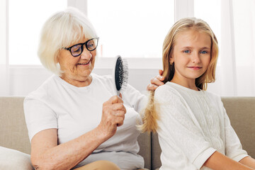 Granddaughter family girl comb child couch love home sofa grandmother - obrazy, fototapety, plakaty