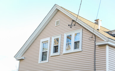 suburban house bathed in warm sunlight symbolizing the American dream of home ownership, facing challenges of mortgage rates and inflation