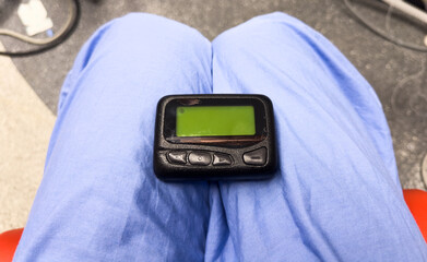 vintage pager on a busy desk, symbolizing hectic work life and essential communication in a...