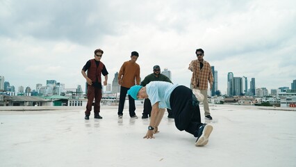 Professional break dance team practice B-boy dance while multicultural friends at rooftop. Young...