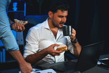 Coworker partners with happy smiling face eating delicious sandwich with coffee while working on...