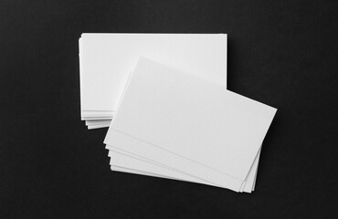 Blank business cards on black background, top view. Mockup for design