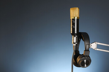 Stand with microphone and headphones on dark background, space for text. Sound recording and reinforcement