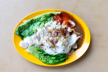 Chee Cheong Fun or Rice noodle roll served with sauces, and a sprinkle of sesame and shallot is popular Chinese food in Malaysia