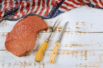 Celebrating America holidays is preparation raw beef steak on table USA flag