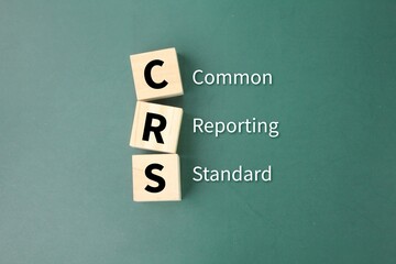 wooden cube with the letters CRS or the word Common Reporting Standard. new information-gathering and reporting requirement for financial institutions