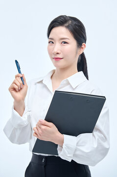 A beautiful Asian woman is making various facial expressions and gestures while holding a document file and a ballpoint pen for business.