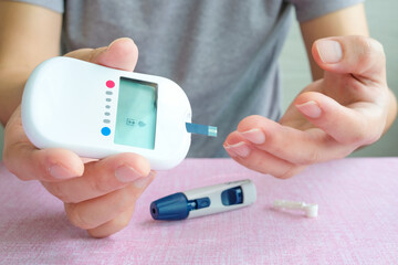 hand of people check diabetes and high blood glucose monitor with digital pressure gauge. Healthcare and Medical concept	