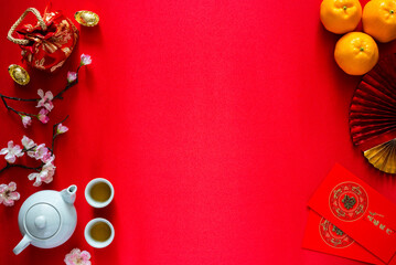 Chinese new year background concept with tea set, ingots(word means wealth), red bag, oranges and...