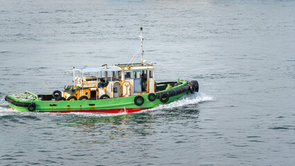 A patrol boat is moving on river in the city. Transportation, water vehicle object.