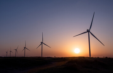 windmills aligned at sunset