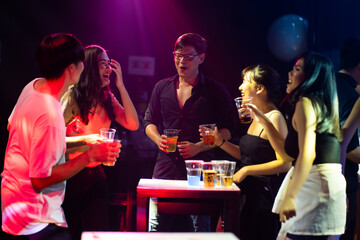 Group of friends having drinks and toasting at the night club party. diverse young people dancing...