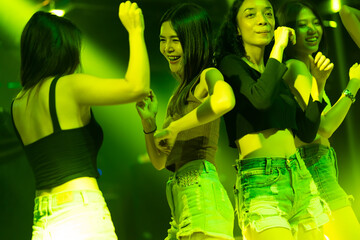 Happy fun Asian thai people drinking in night club. diverse young people dancing in night club. Nightlife and disco dance party concept. Fun music festival