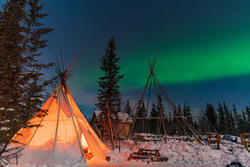 Aurora Borealis, Northern Lights, over aboriginal tent teepee at Yellowknife, Northwest Territories, Canada © momo11353