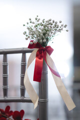white chair with red and white flowers decoration in wedding ceremony